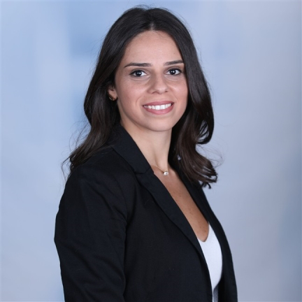 Woman wearing a black blazer against a light blue background