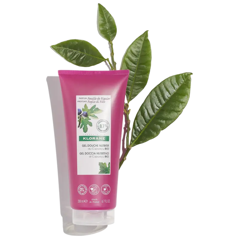 Pink tube of Klorane with green leaves